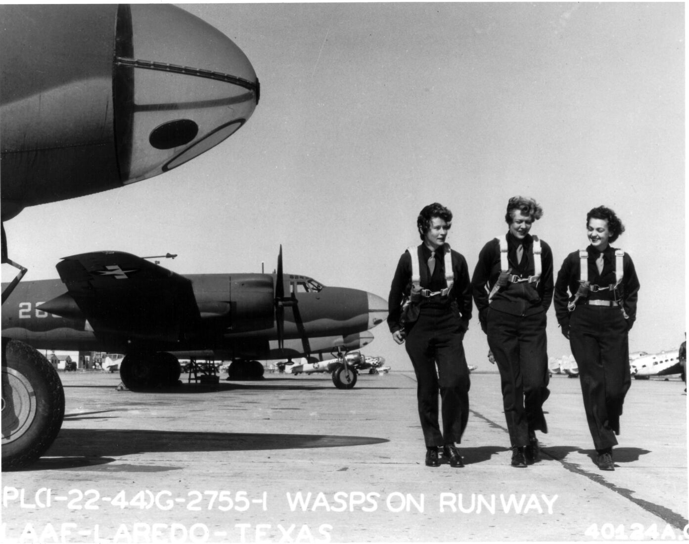 Three Women Airforce Service Pilots walking on a Texas flight line in 1944